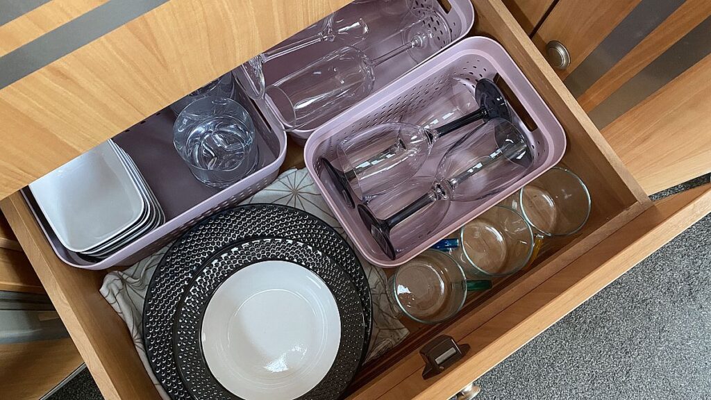 Plates and glasses in a drawer in a camping kitchen
