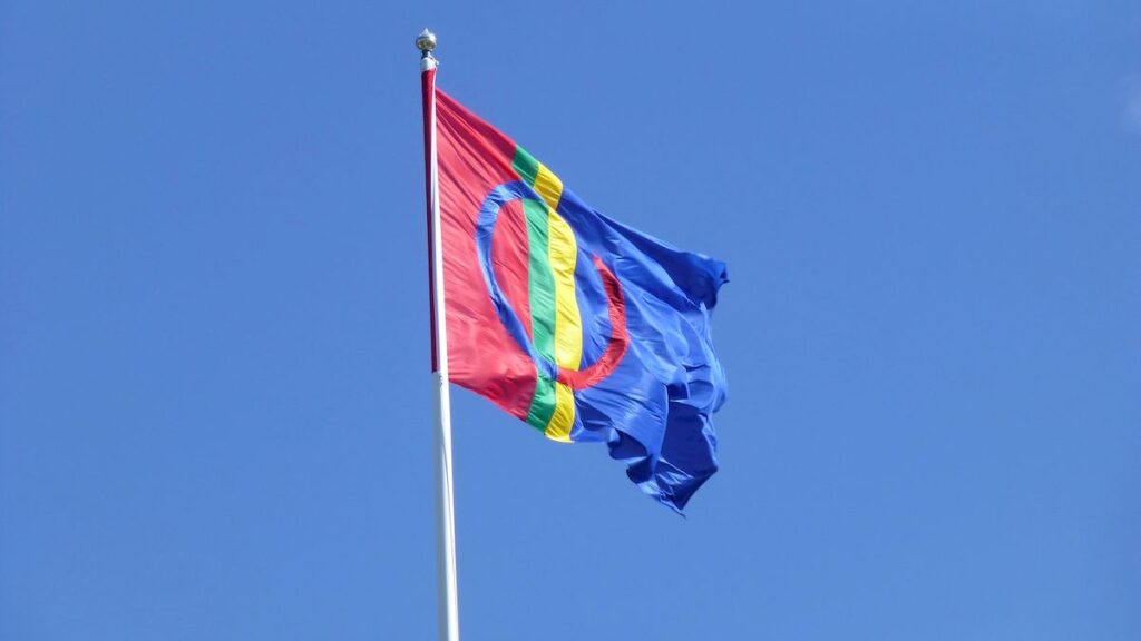 The Sami flag flies on a flagpole